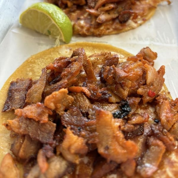 Two Holy Taco al pastor tacos with a lime wedge on the side.